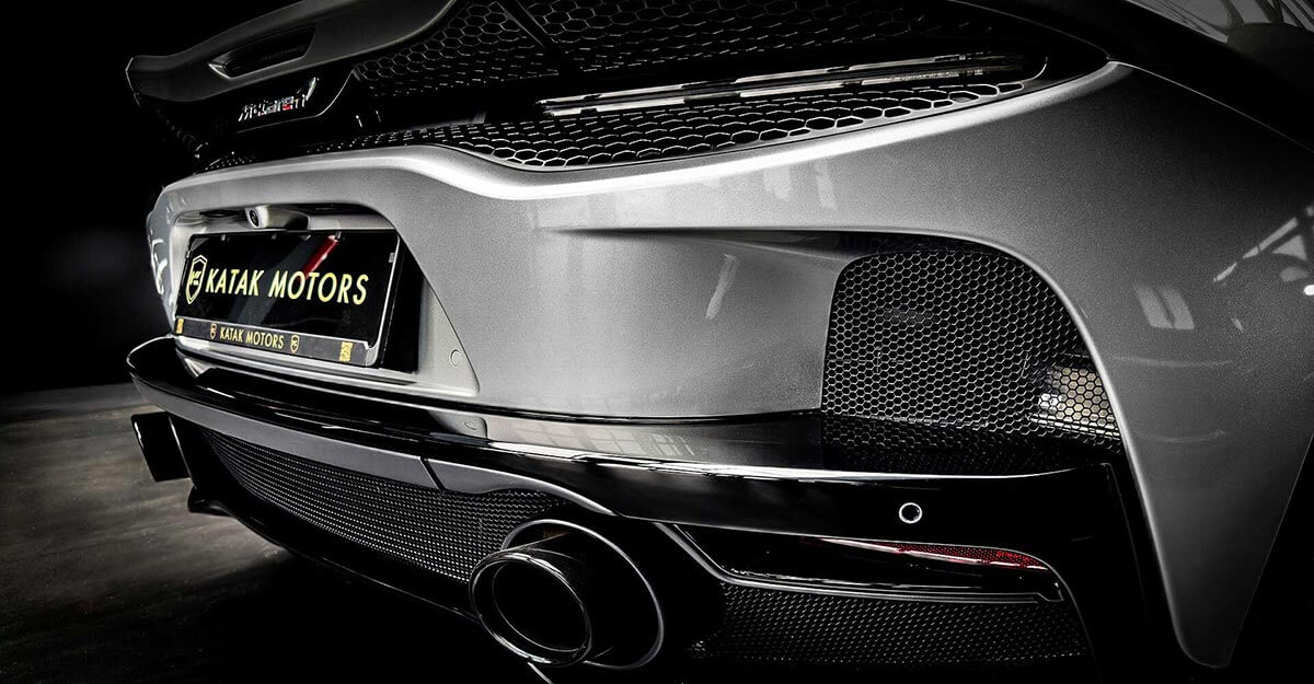 McLaren GT in silber im Autohaus von Katak Motors. Nahaufnahme vom Auspuff, Stoßstange und Kennzeichenhalter.